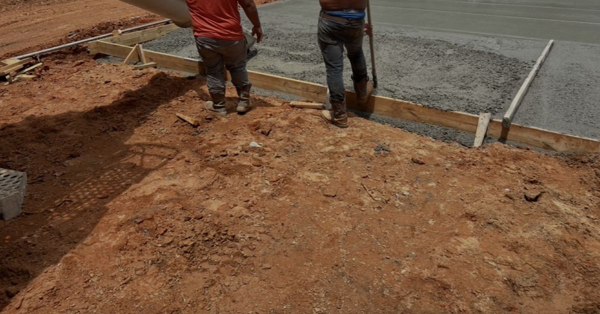 Crew working a fresh concrete pour inside wood forms